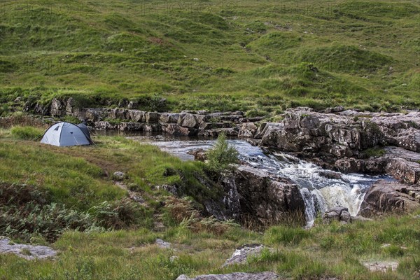 Wild camping with light dome tent along the River Etive in Glen Etive near Glencoe in the Scottish Highlands