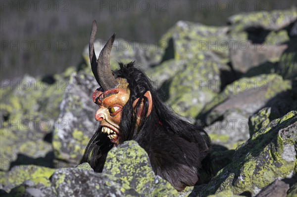 Creepy wooden devil figure on the summit of the Lusen in autumn