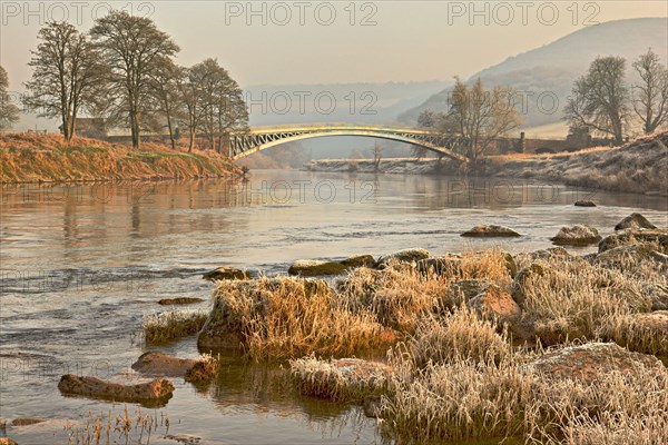 View of river and bridge at frost at dawn