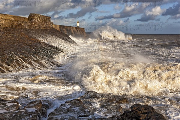 Wave-bombed seafront and coastal town lighthouse