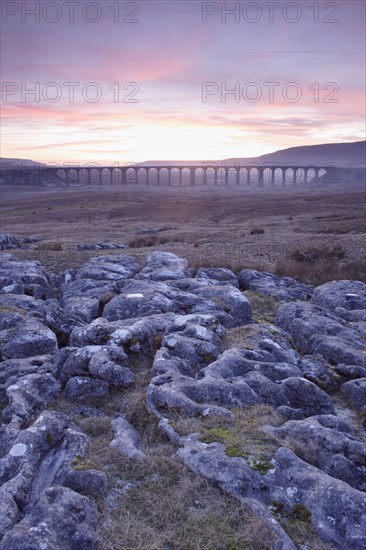 View of limestone cliffs and Ribblehead viaduct at sunset