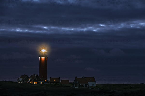 Eierland lighthouse with lantern light over the Wadden Sea at night on the Dutch island of Texel