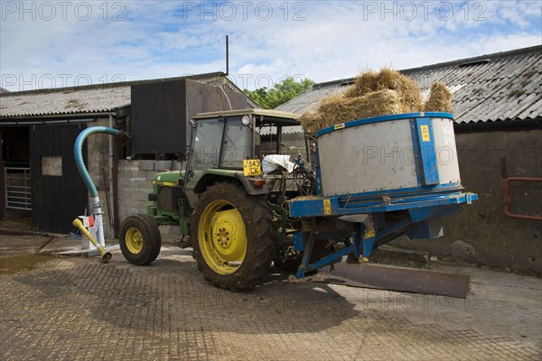 John Deere 2450 tractor with straw bedding machine on dairy farm