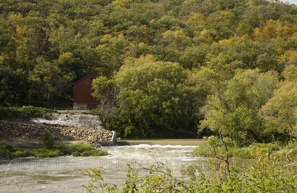 View of weir on river and wooded hillside