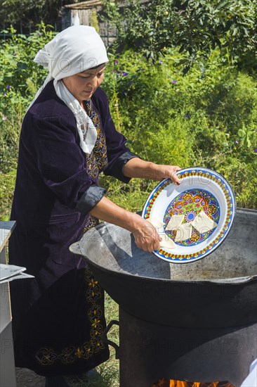 Kazakh woman preparing traditional local tandyr bread