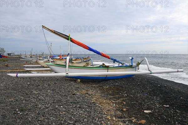 Traditional colourful outrigger boats on the black lava beach of Lovina