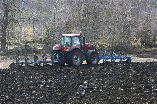Tractor ploughing with front- and rear-mounted plough