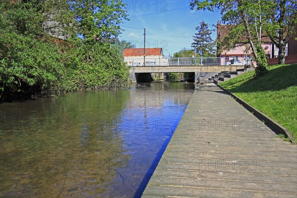 View of boardwalk alongside river in town