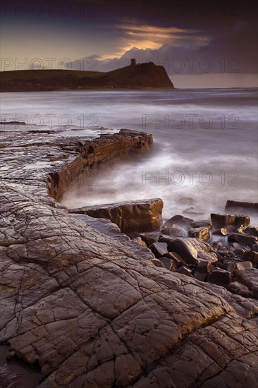 View of wave-cut platform and rocky coastline at sunset