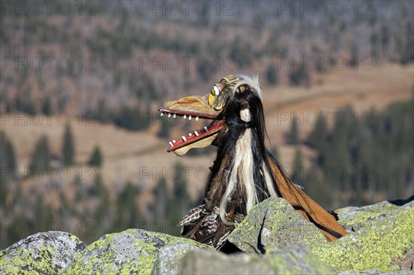 Creepy wooden devil figure on the summit of the Lusen in autumn