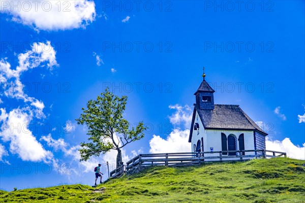 Hikers in front of the Postalm Chapel