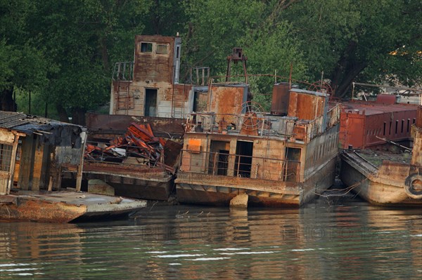 Rusting boats at edge of river