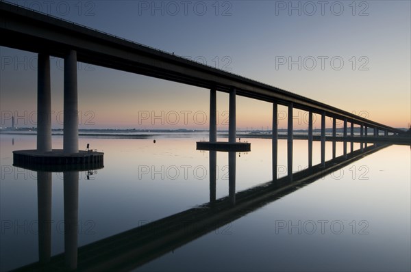 View of the bridge reflected in the estuary at dawn