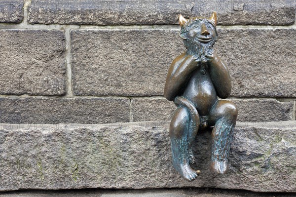 Cute little bronze devil sculpture on the Devil's Stone at St. Mary's Church in Luebeck