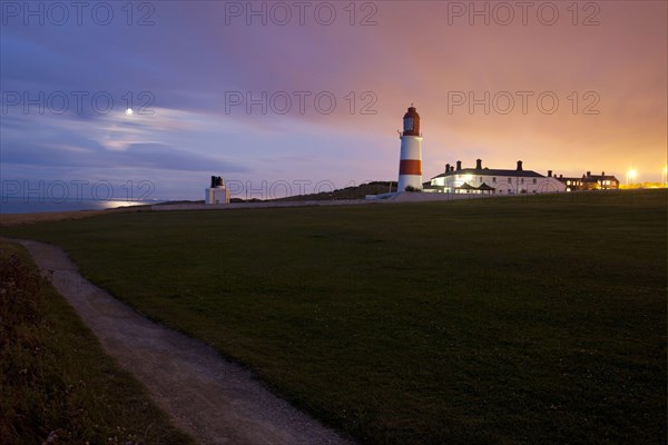 View of the coastline and lighthouse at sunset