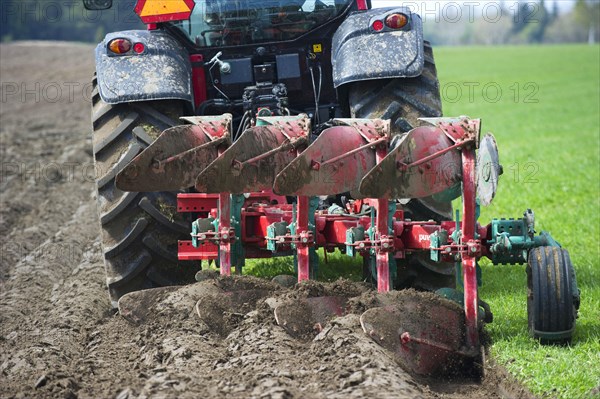 Valtra tractor ploughs field with four-furrow reversible plough