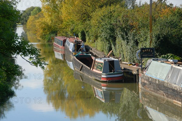 Narrowboats moored at boatyard on canal