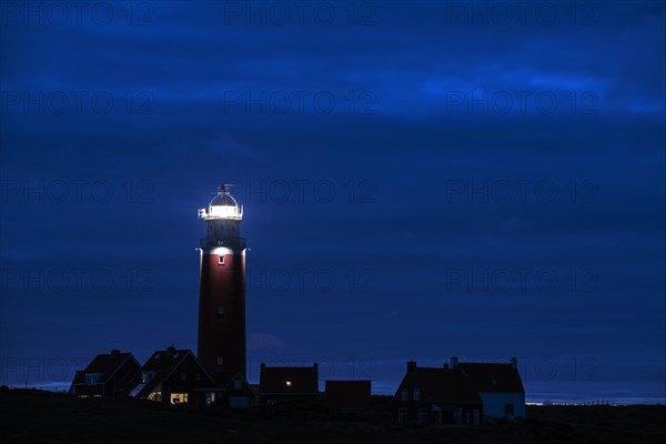Eierland lighthouse with lantern light over the Wadden Sea at night on the Dutch island of Texel