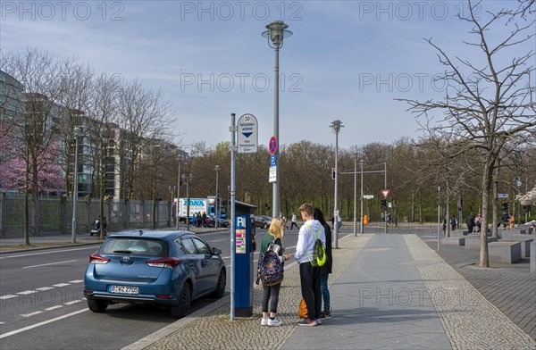 Young people standing next to a parking machine