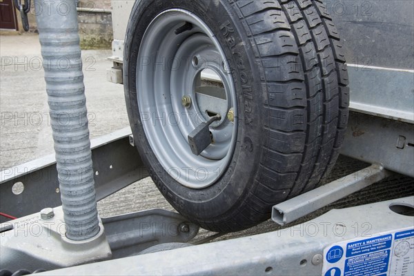 Spare wheel lock on farm trailer in farmyard