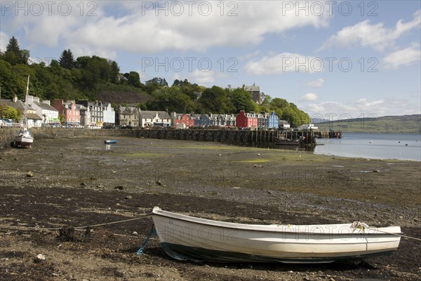 View of boats in harbour of coastal town at low tide