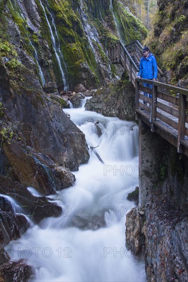 Tourist looking at the waterfall in the Wimbachklamm gorge in Ramsau bei Berchtesgaden