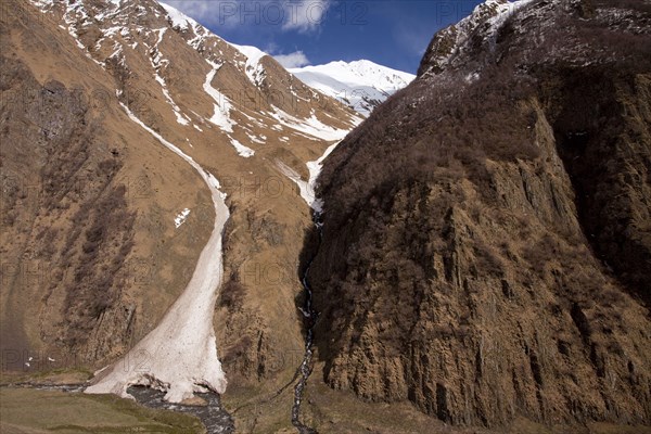 View of the snow melting in the valley of the mountain river