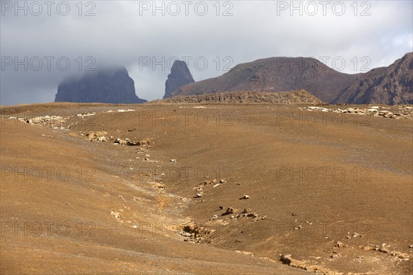 Dry landscape with yellow sand and volcanic peaks on the island of Sao Nicolau