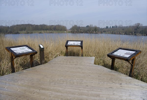 Boardwalk and information boards overlooking the lake in a flooded former limestone quarry