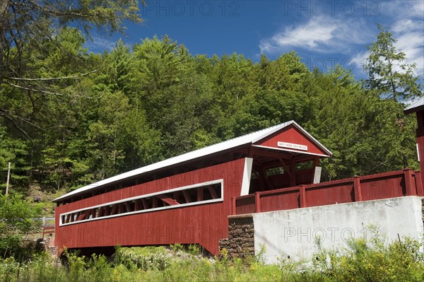 View of covered bridge crossing river