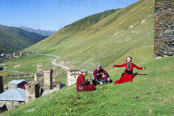 Georgian people from a folkloric group playing panduri and dancing in traditional Georgian dress