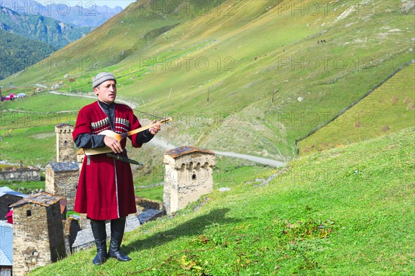 Georgian musician of a folklore group playing panduri