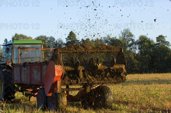 John Deere tractor pulling manure spreader