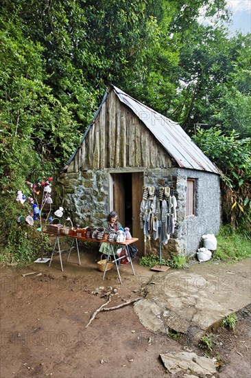 Woman sitting in front of stone house