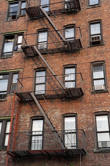 Fire escape ladders on side of brick apartment buildings