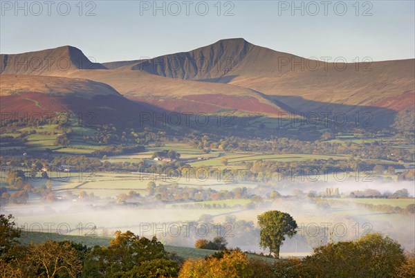 View of farmland and hills at sunrise