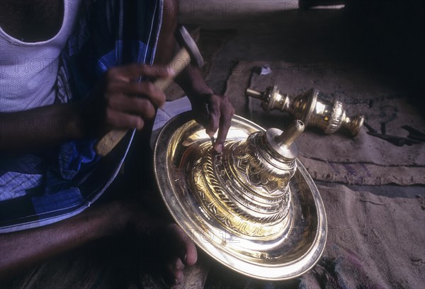 An artisan working on brass lamp at Nachiyar Koil near Thanjavur