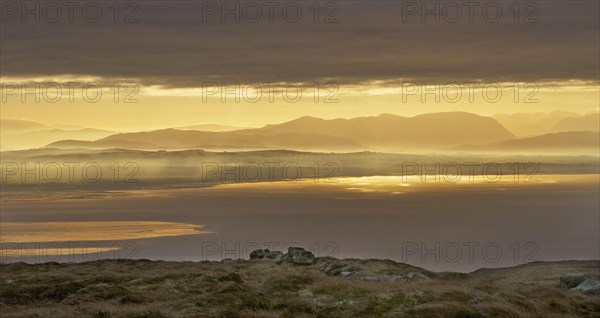 View across bay towards distant hills at sunrise