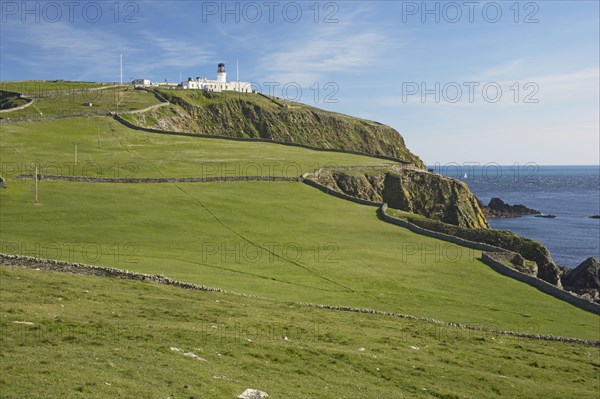 View of cliff pasture and distant lighthouse