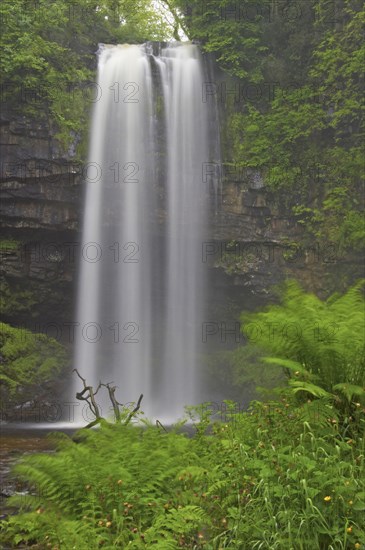 Waterfall flowing over a defaced sandstone rim