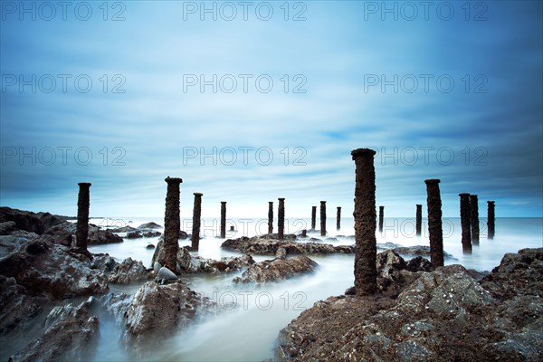 Steel supports of the ruined Victorian pier visible on the shore at low tide