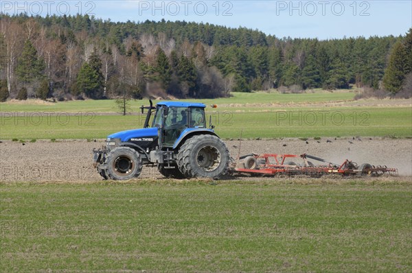 New Holland TM165 tractor with harrows