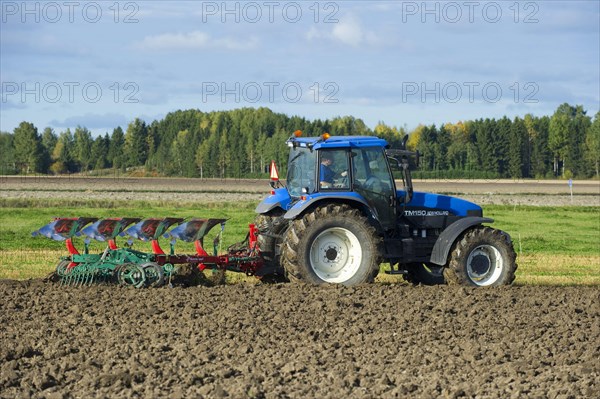 New Holland TM150 tractor with reversible plough and harrow