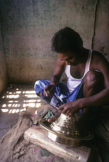 An artisan working on brass lamp at Nachiyar Koil near Thanjavur