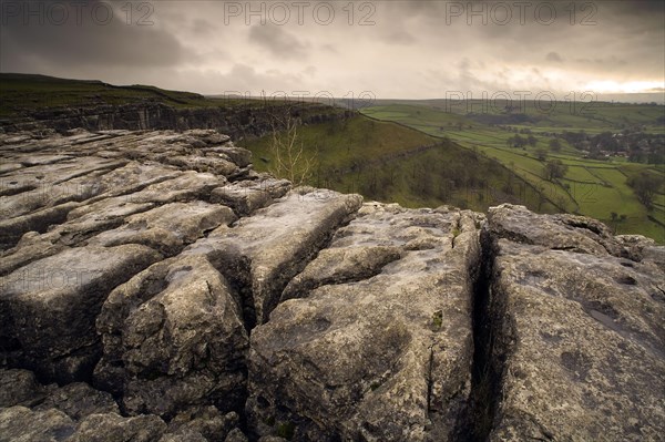 View of limestone pavement in upland landscape at sunset
