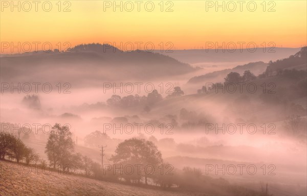 View of mist and frost in valley at sunrise