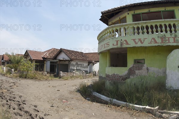 Abandoned village in dried mud after mud volcano flooded by mud lake