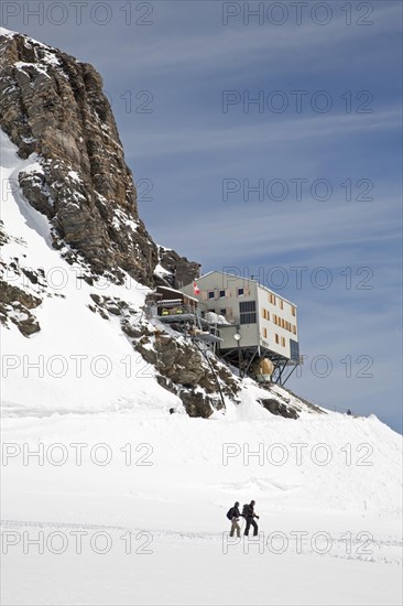 Hikers on snow-covered mountain below the mountain hut