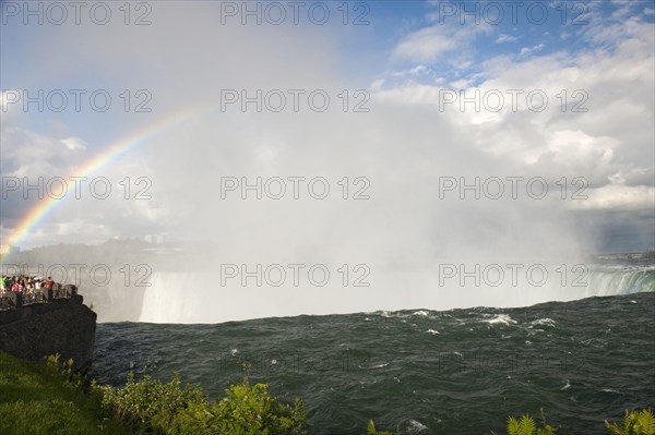 Rainbow forming in spray over waterfall