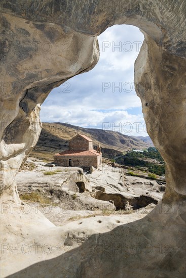 Christian princely basilica from the 10th century with view through a rock arch